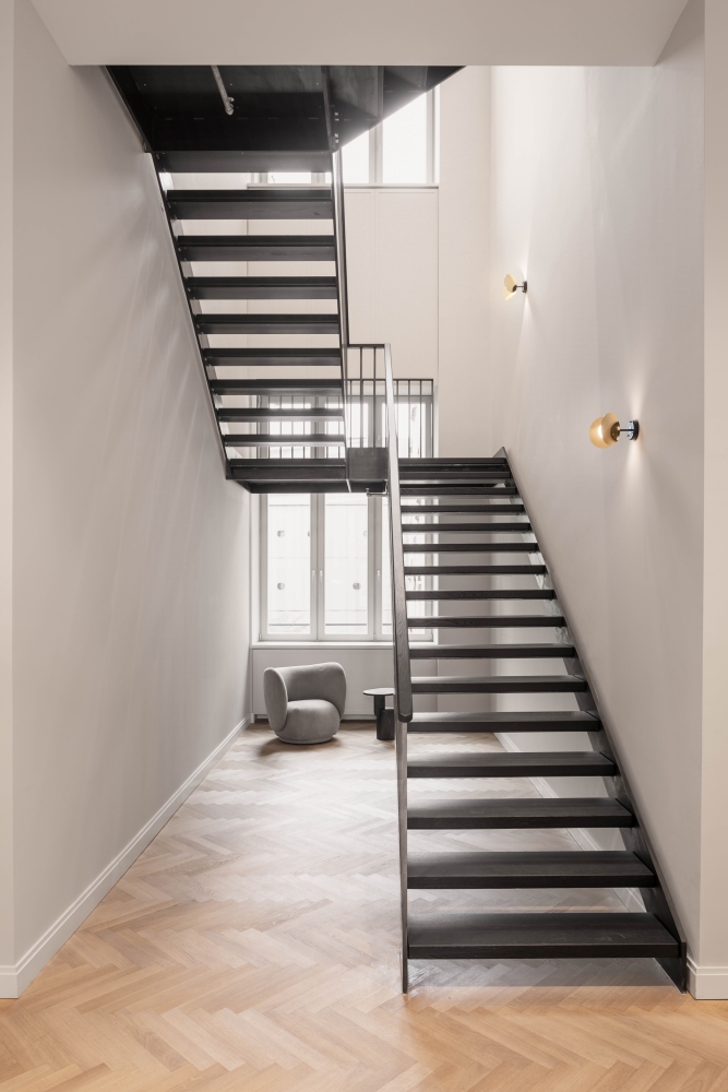 Steel staircase, herringbone parquet, armchairs, window, wall lights, bright, open